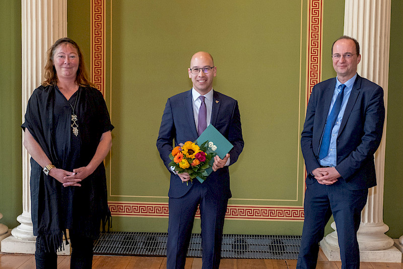 Dr. Kim Philip Linoh (Mitte) - hier mit Prorektorin Christine Fürst und Betreuer Dirk Hanschel - erhielt einen Dorothea-Erxleben-Preis