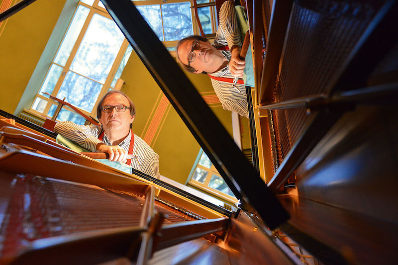 „Ich wundere mich, wie lange manche Leute ein verstimmtes Klavier ertragen können“, sagt Gerald Seupt, hier bei der Arbeit am Steinway-Flügel in der Aula.