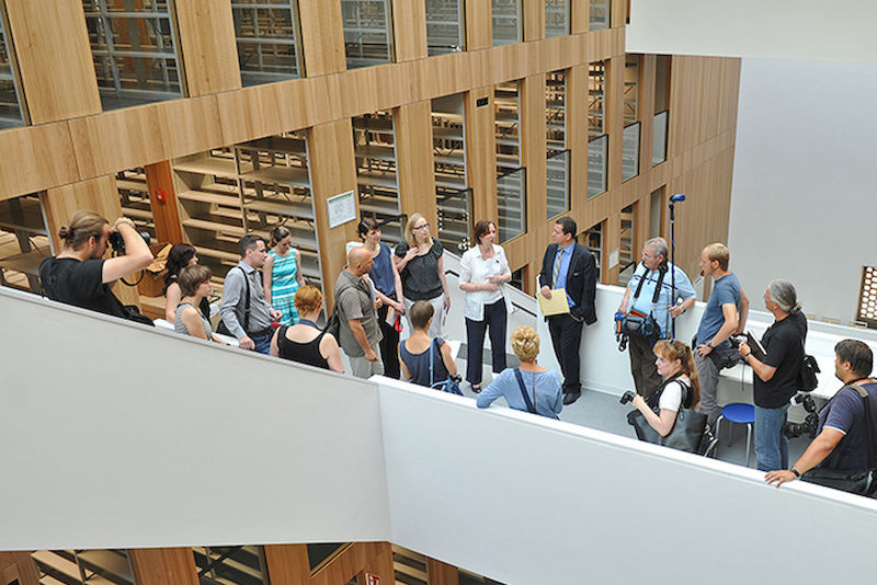 Journalisten, Fotografen und Uni-Verantwortliche beim Rundgang durch die Bibliothek.