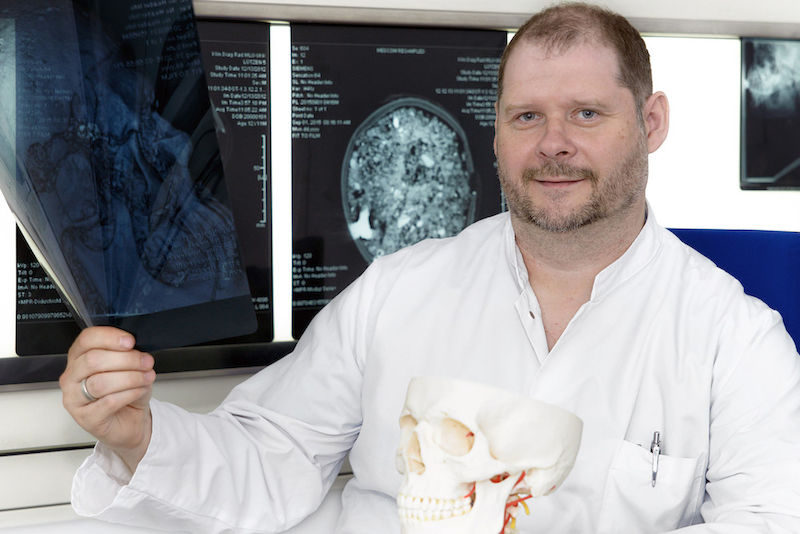 Oberarzt Silvio Brandt mit Röntgenbildern von Opfern der Schlacht. Viele Schädel wiesen Schussverletzungen auf.