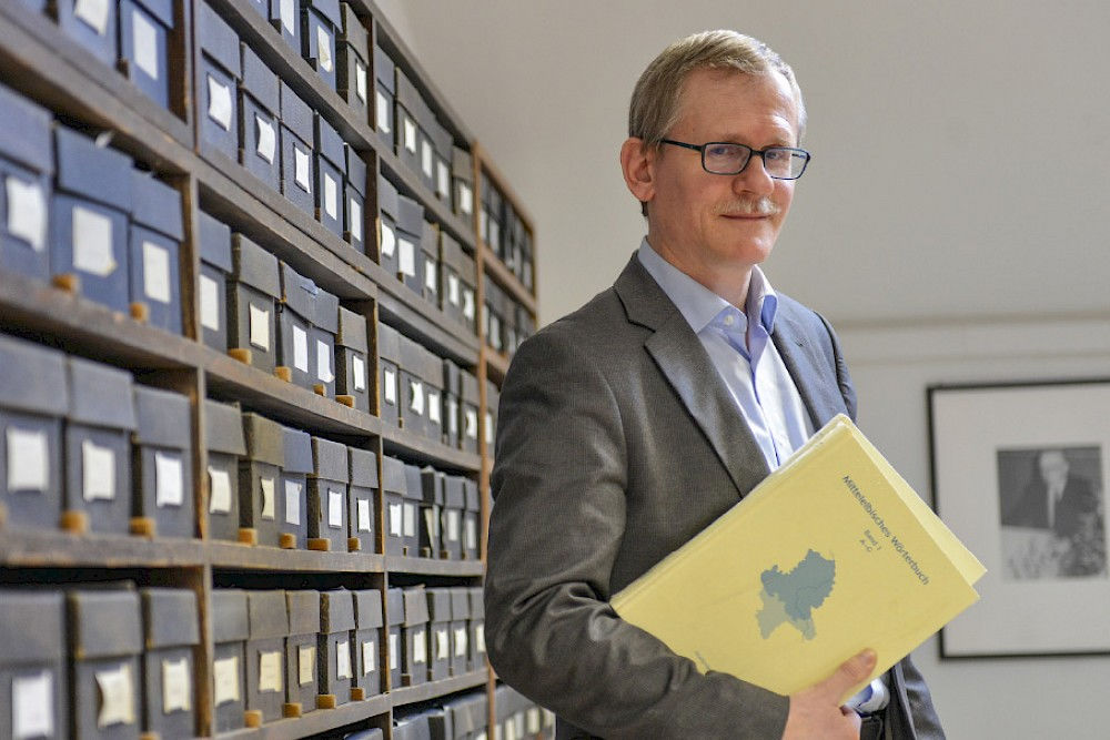 Ulrich Wenner mit einem Band des Mittelelbischen Wörterbuchs im Karl-Bischoff-Archiv der Universität.