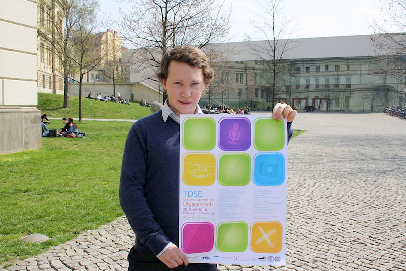 Mitorganisator Marwin Gaube mit dem Plakat zum Tag des studentischen Engagements.