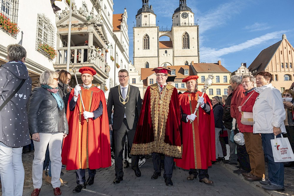 Der Weg des Akademischen Senats führte über den Markt, im Hintergrund sind die Türme der Stadtkirche Wittenberg zu sehen.