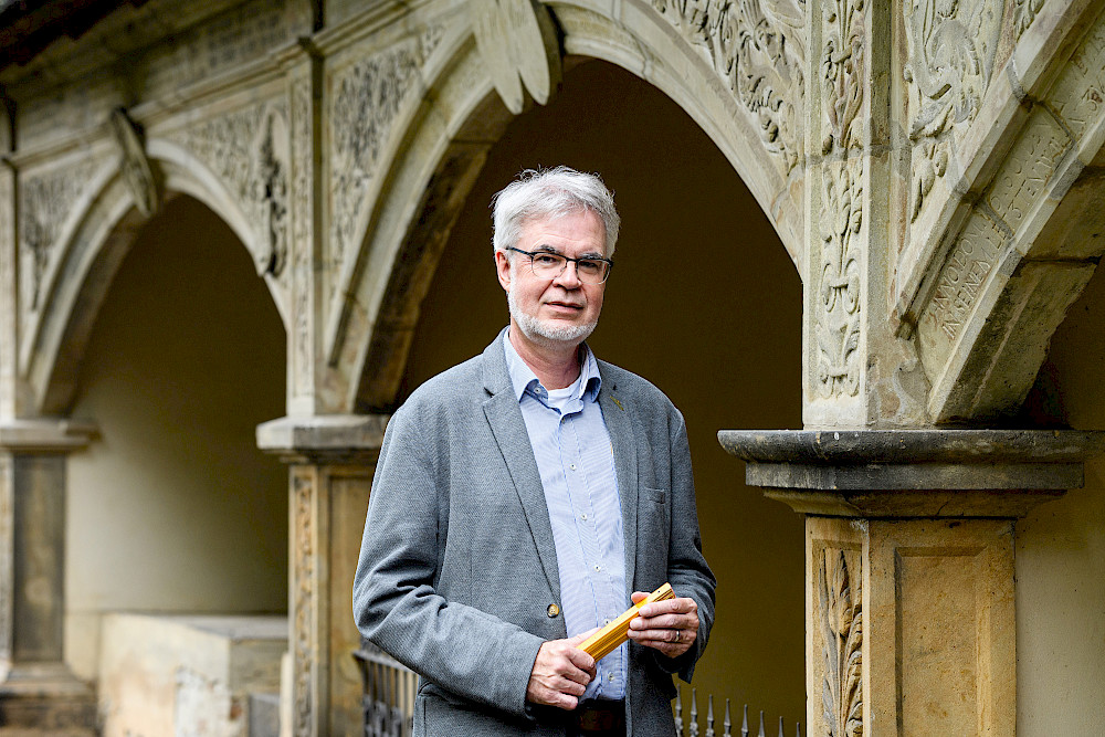 Klaus Krüger steht vor einem Bogen auf dem Stadtgottesacker.