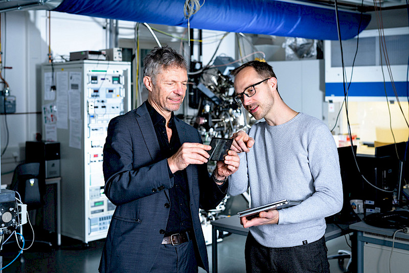 Roland Scheer (links) und Stefan Förster betrachten ein Solarmodul.
