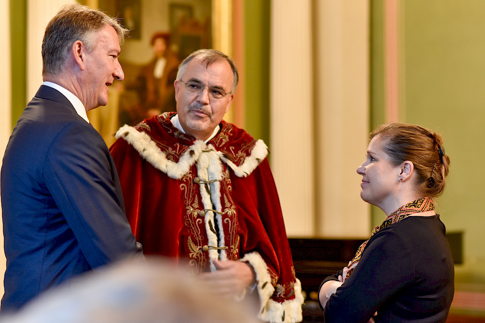 Ministerin Franziska Weidinger im Gespräch mit Dekan Henning Rosenau und dem Geschäftsführenden Direktor der Deutschen Anwalt- und Notarversicherung Peter Dümpelmann.