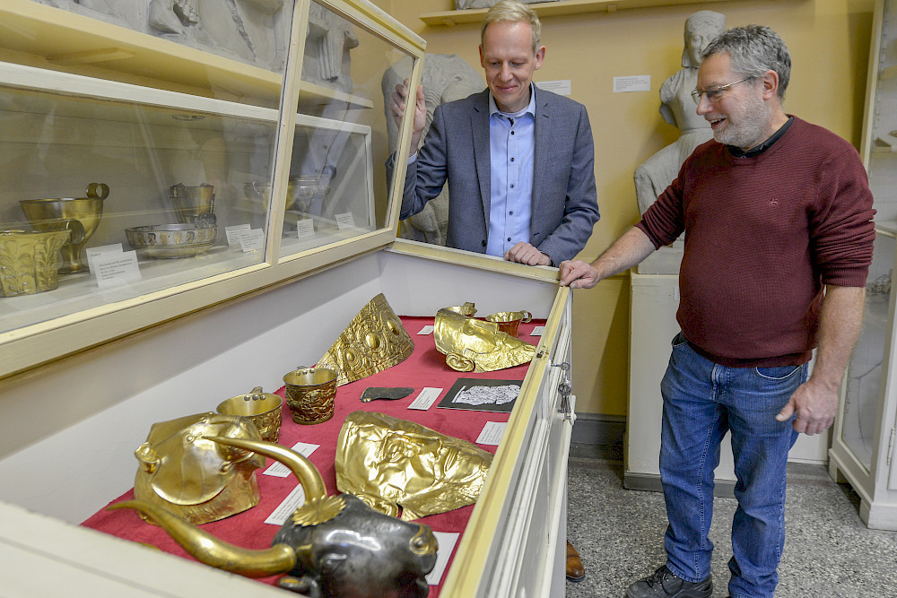 Kustos Stephan Faust (links) und Mitarbeiter Henryk Löhr stehen vor der Vitrine mit  Galvanoplastiken.