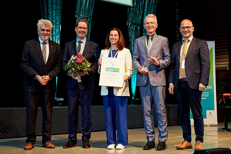 Wissenschaftsminister Armin Willingmann gemeinsam mit dem Gewinnerteam der MLU mit Arne Viestenz, Joana Heinzelmann und Karsten Mäder sowie Jury-Mitglied Emrah Düzel (v.l.n.r.)