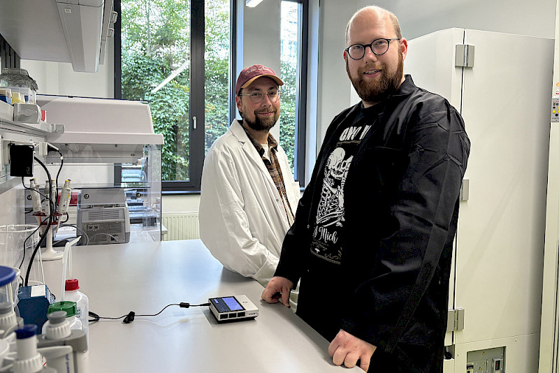 Peter Dietrich (links) und Doktorand Michael Köhler im Labor - mit dem mobilen Gerät vor ihnen können die Proben sequenziert werden.