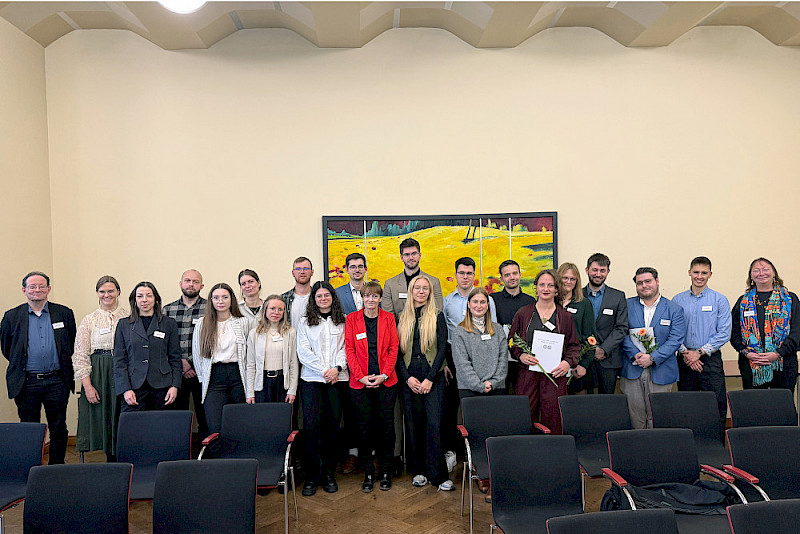 Gruppenfoto mit den neuen Stipendiatinnen und Stipendiaten, Peter Hinrichs vom Wissenschaftsministerium (links) und Prorektorin Christine Fürst (rechts)