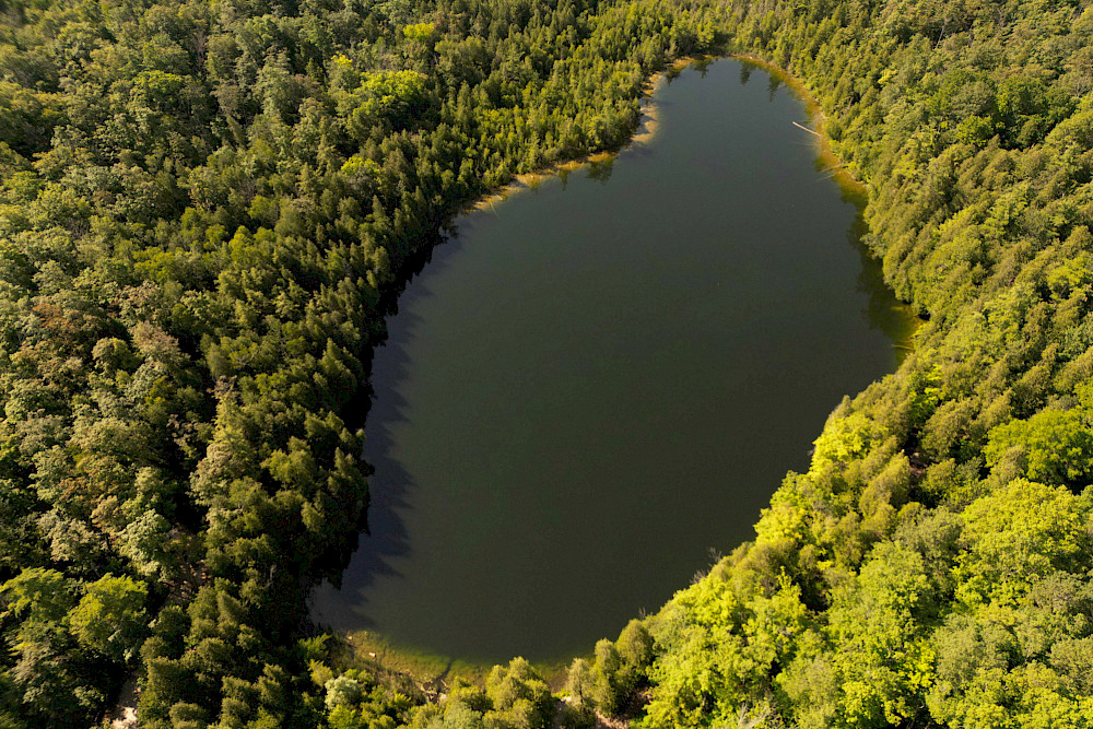 Der Crawford Lake in Kanada gilt als Referenzort für das Anthropozän. In seinen jährlichen Sedimentschichten haben sich Spuren menschlicher Eingriffe wie Industrieemissionen, Stickstoff aus der Landwirtschaft und radioaktives Plutonium aus Atomtests seit Mitte des 20. Jahrhunderts eingeschrieben.