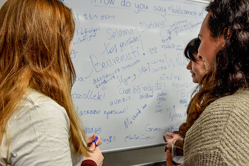 Im "International Café" trafen sich internationale Studierende und notierten in ihrer Sprache das Wort "Willkommen".